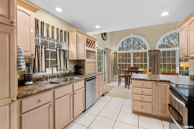 kitchen with light brown cabinetry, sink, light tile patterned floors, and stainless steel dishwasher