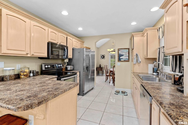 kitchen with kitchen peninsula, appliances with stainless steel finishes, light brown cabinetry, and sink