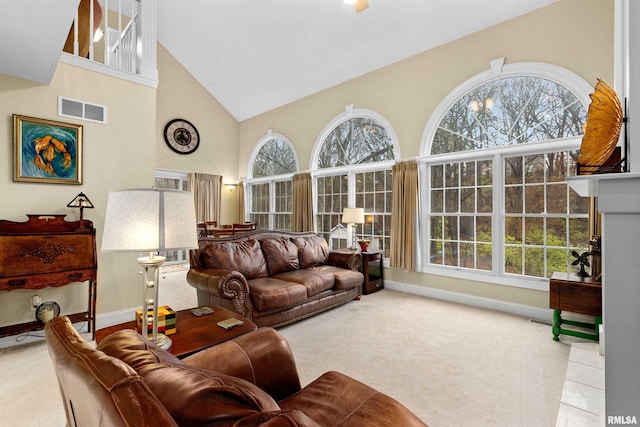 carpeted living room with plenty of natural light and high vaulted ceiling