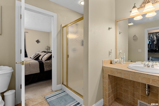 bathroom with tile patterned floors, a shower with shower door, sink, and a textured ceiling