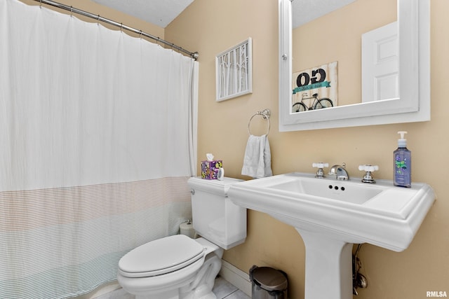 bathroom featuring tile patterned floors, a textured ceiling, and toilet