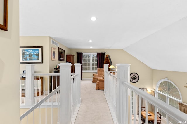 hall featuring light colored carpet and vaulted ceiling