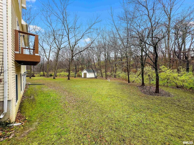 view of yard with a balcony and a storage shed