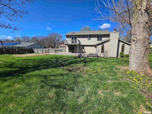 rear view of house with a deck and a lawn