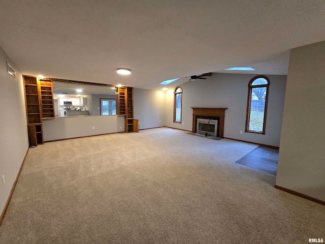 unfurnished living room featuring carpet and ceiling fan