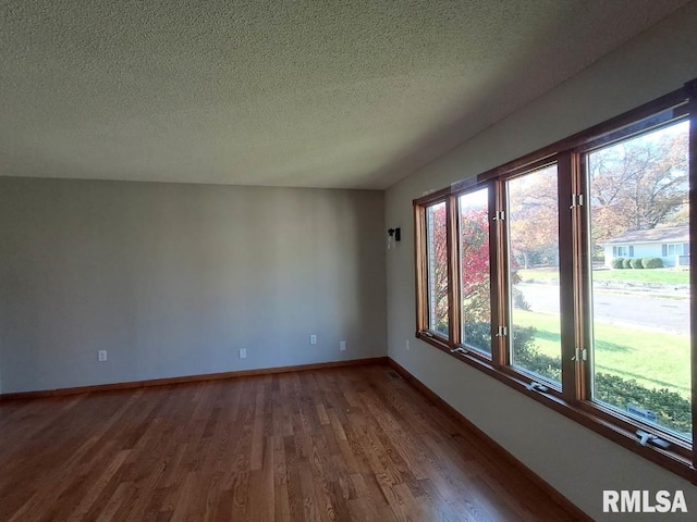 spare room with hardwood / wood-style floors and a textured ceiling