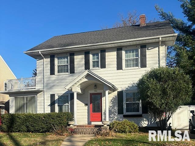 colonial-style house with a front lawn