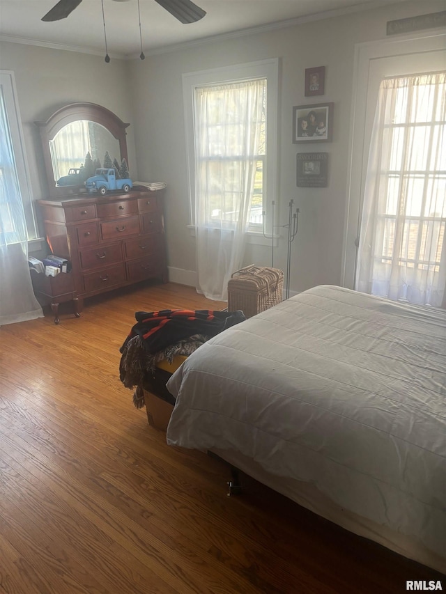 bedroom featuring light hardwood / wood-style flooring, ceiling fan, and ornamental molding