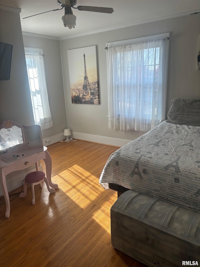 bedroom featuring wood-type flooring, ceiling fan, and crown molding