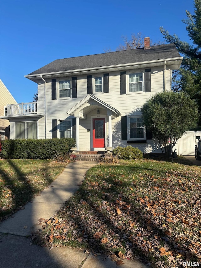 colonial-style house featuring a front yard