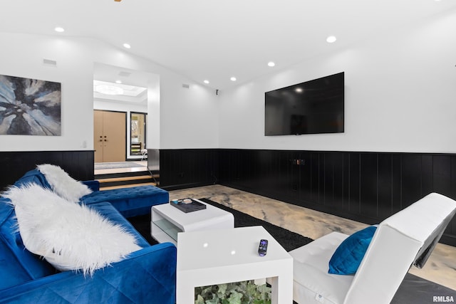 living area with lofted ceiling, a wainscoted wall, wood walls, and recessed lighting