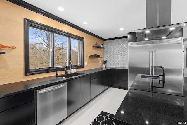 kitchen featuring dark countertops, ornamental molding, stainless steel appliances, open shelves, and a sink