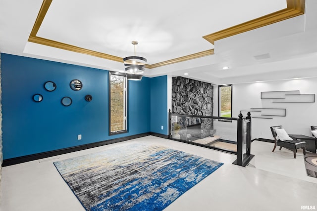 interior space featuring ornamental molding, a raised ceiling, baseboards, and an inviting chandelier