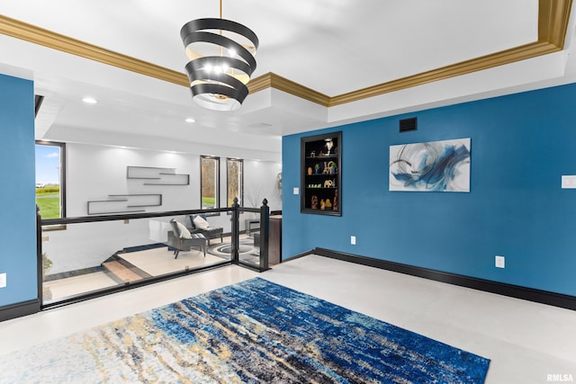 interior space with built in shelves, a tray ceiling, and crown molding