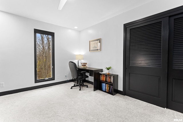 home office with light carpet and baseboards