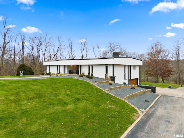 view of front of house with a front yard and a chimney