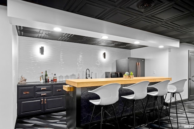 bar featuring an ornate ceiling, indoor wet bar, freestanding refrigerator, a sink, and recessed lighting