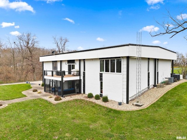 rear view of house featuring central AC, a yard, and a balcony