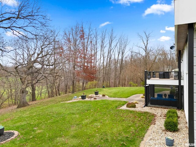 view of yard featuring an outdoor fire pit and a balcony