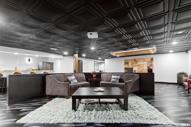 living area featuring an ornate ceiling, baseboards, and dark wood finished floors