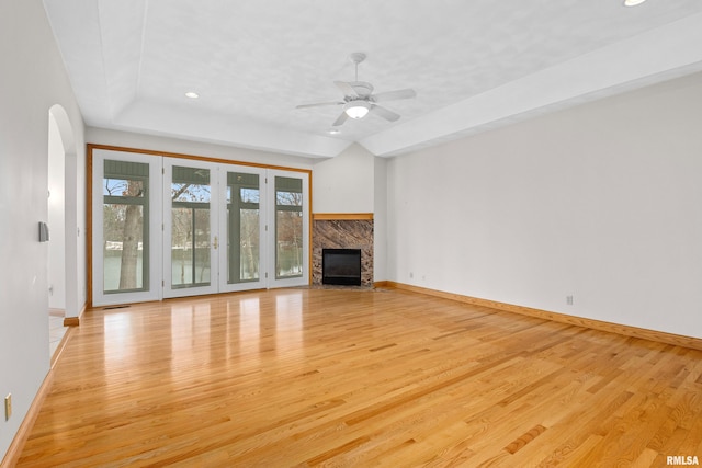 unfurnished living room featuring a fireplace, ceiling fan, and light hardwood / wood-style flooring