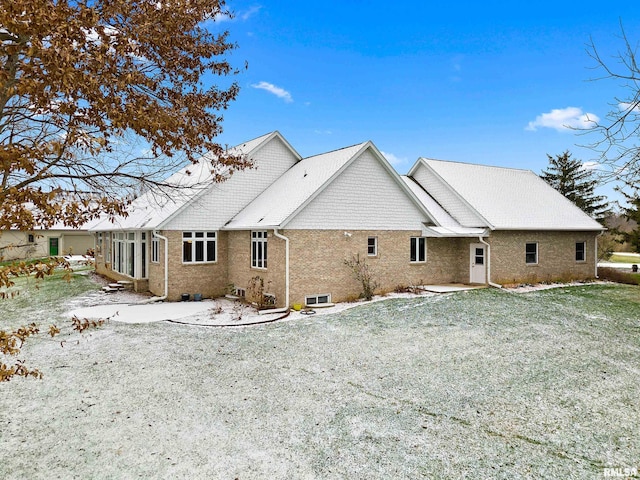 snow covered property with a lawn