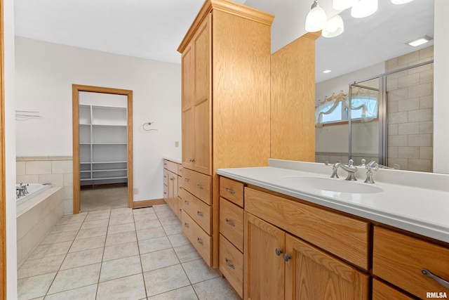 bathroom with tile patterned flooring, vanity, and separate shower and tub