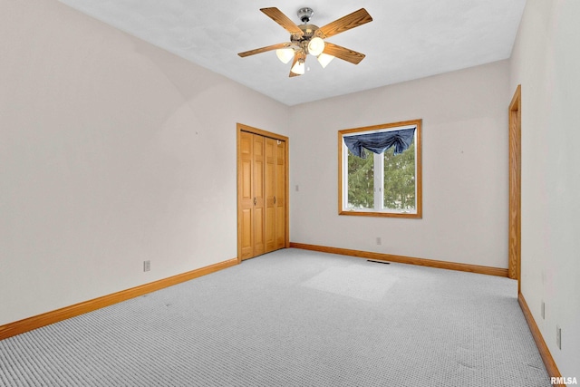 empty room with ceiling fan and light carpet