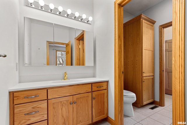 bathroom featuring tile patterned flooring, vanity, and toilet