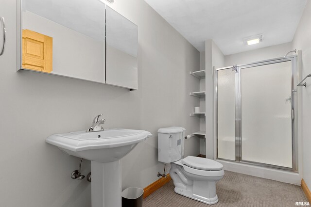 bathroom featuring toilet and a shower with door