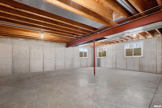 basement with brick wall and a wealth of natural light