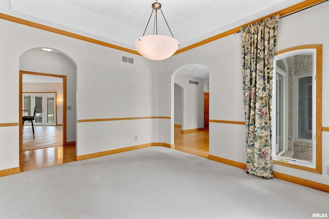 spare room featuring light hardwood / wood-style floors and crown molding