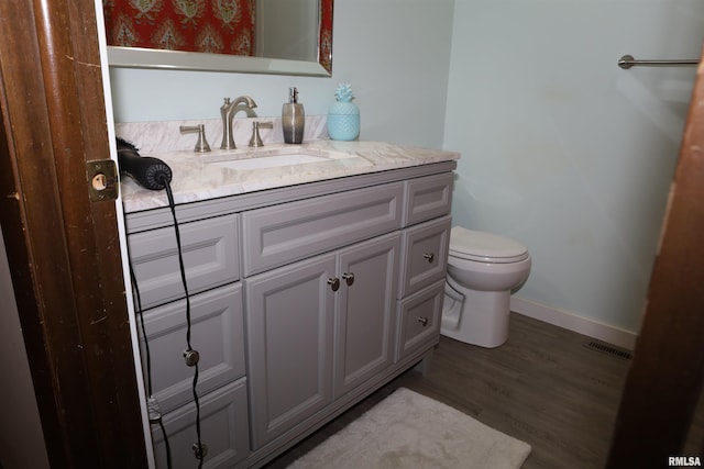 bathroom featuring vanity, wood-type flooring, and toilet