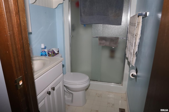 bathroom featuring tile patterned floors, vanity, an enclosed shower, and toilet