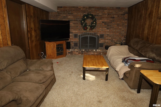 living room with carpet, a brick fireplace, and wood walls