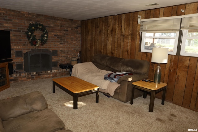 living room with light colored carpet, a fireplace, and wooden walls