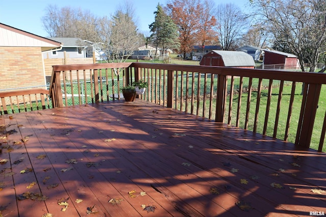 wooden deck with a shed and a lawn