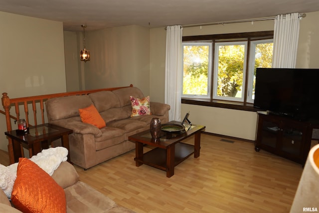 living room with a chandelier and light wood-type flooring