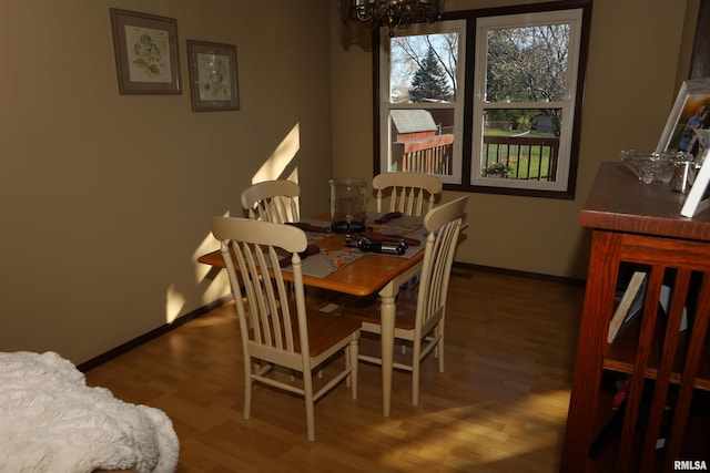 dining room featuring wood-type flooring and a chandelier