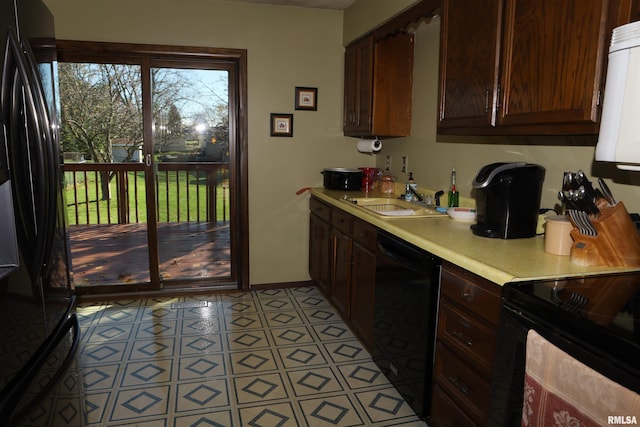 kitchen with sink, light tile patterned floors, and black appliances