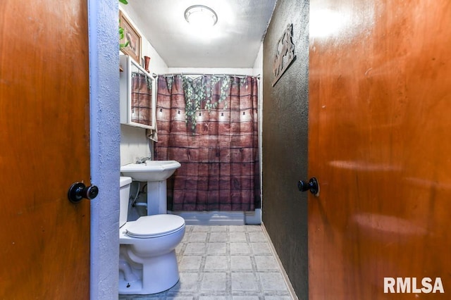 bathroom featuring sink, toilet, and walk in shower