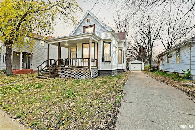 view of front facade with an outbuilding, a porch, a garage, and a front yard