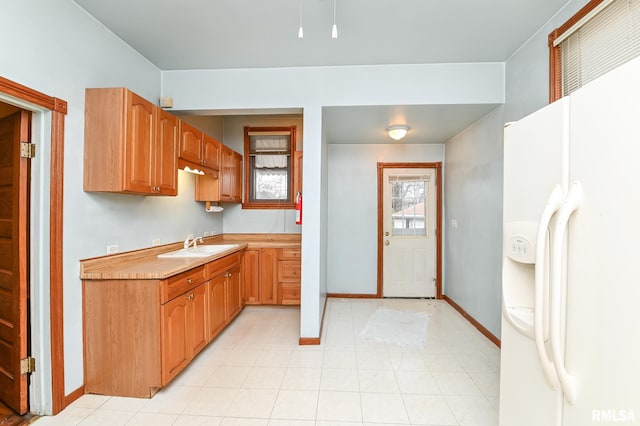 kitchen featuring white fridge with ice dispenser and sink