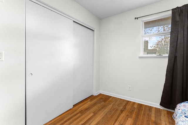 unfurnished bedroom featuring a closet and wood-type flooring