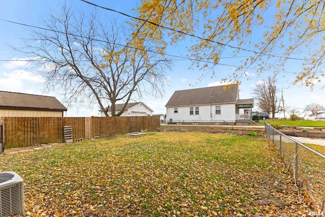 back of house with a lawn and central AC unit