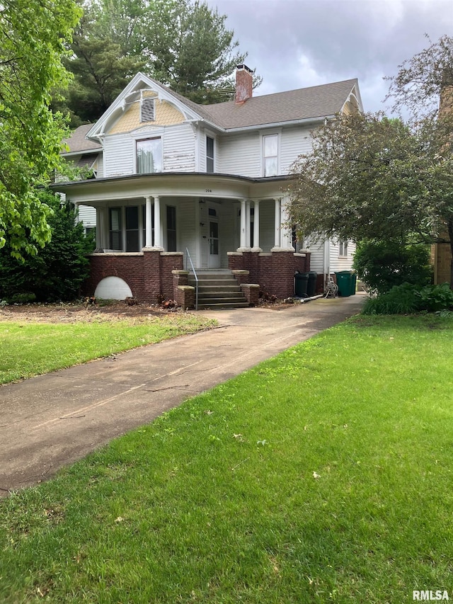 704 S Lafayette St, Macomb, IL 61455 - victorian-style house featuring covered porch, a front lawn, a chimney, and brick siding