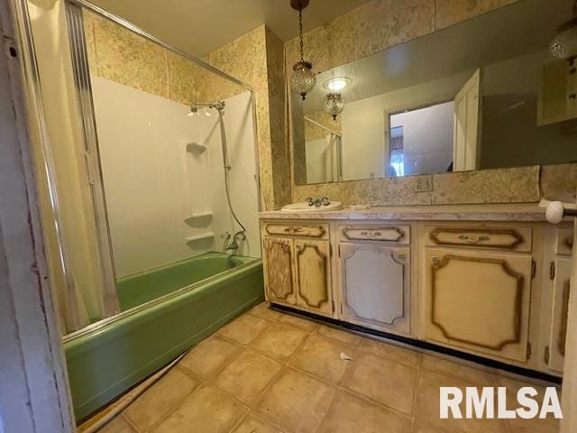 bathroom featuring tile patterned flooring, vanity, and tiled shower / bath