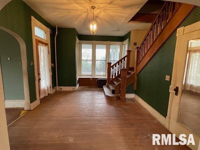 foyer with wood-type flooring and radiator heating unit