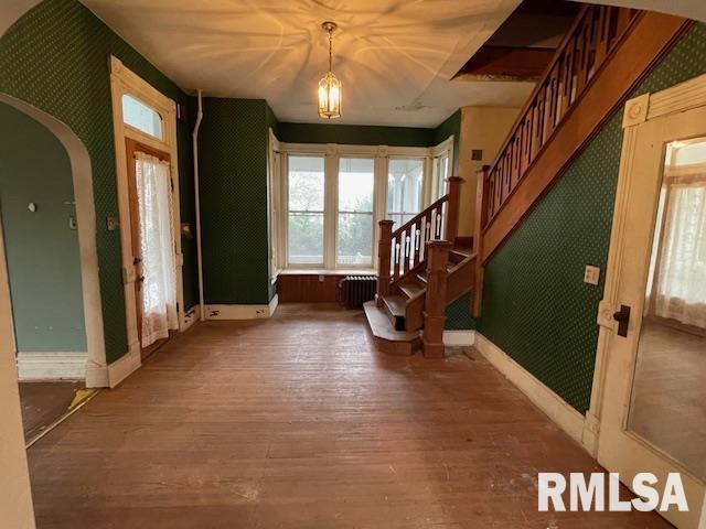 704 S Lafayette St, Macomb, IL 61455 - foyer featuring radiator heating unit, wallpapered walls, hardwood / wood-style floors, stairway, and baseboards