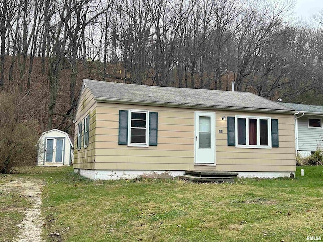 view of front facade with a storage unit and a front lawn